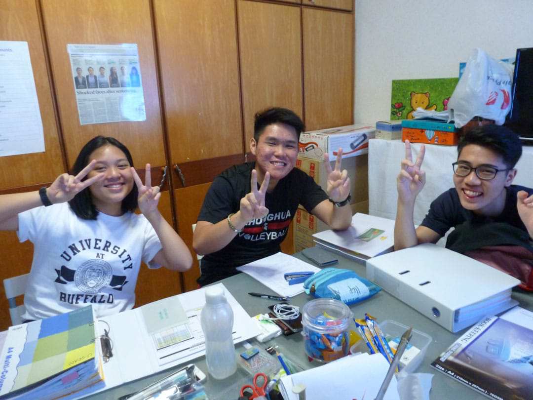 photo of 3 students doing a victory sign photo of 3 students doing a victory sign