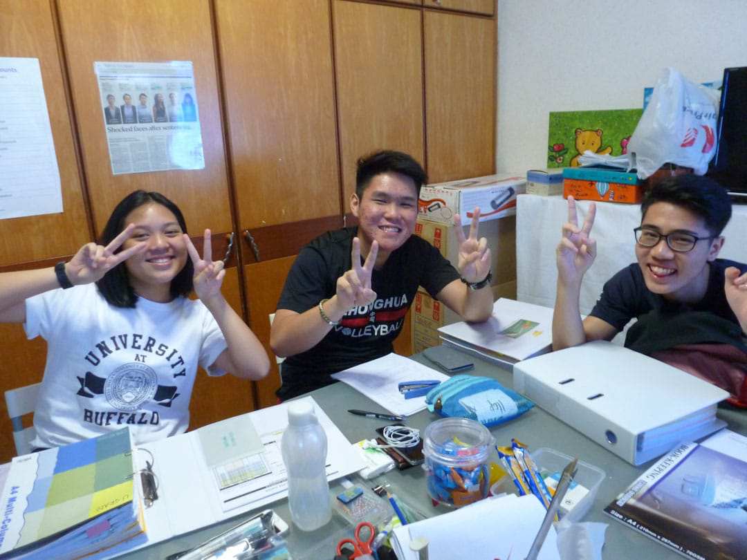 photo of 3 students doing a victory sign