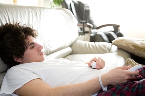 a bored man slouching on the couch